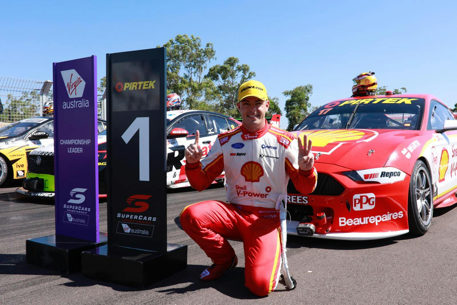 Supercar Driver posing next to signage